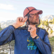 A person outside zipping up the face net on a bug net jacket