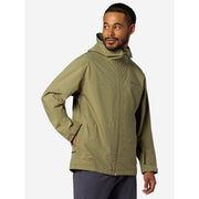 A man wearing an olive green hooded rain jacket with a full-zip front and zippered chest pocket, shown from the waist up against a light gray studio background.