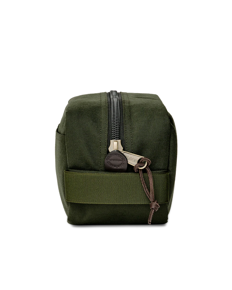 Side view of a dark green travel bag against a white background. 