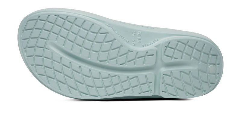 Close-up of a light blue shoe sole with tread pattern on a white background