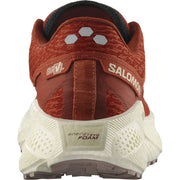 The back of a dark orange sneaker with cream-colored, thick stack midsole and dusky purple accents and treads, with visible Salomon branding, energy evofoam, and GRVL model labels on a white background