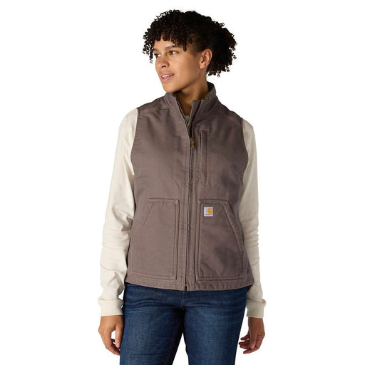 Woman wearing a taupe colored vest against a white background. The vest has one zipper pocket on the chest, as well as two pouch pockets towards the bottom. 