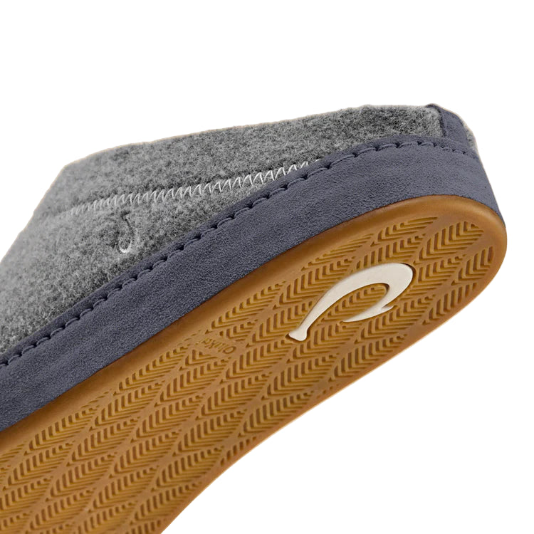 Close-up of a shoe sole with a brand logo on a beige background