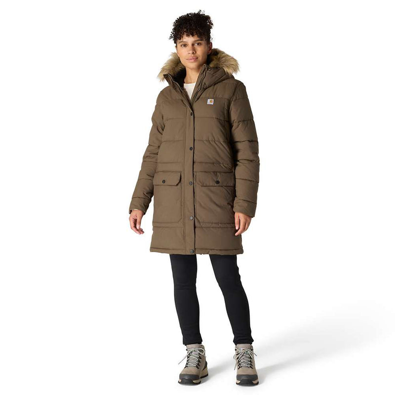 Woman with curly dark hair and light brown skin wearing a brown parka with faux fur trimmed hood, dark skinny jeans, and taupe winter boots. The parka hits a few inches above her knees, she is listed as 5 feet 8 inches tall.