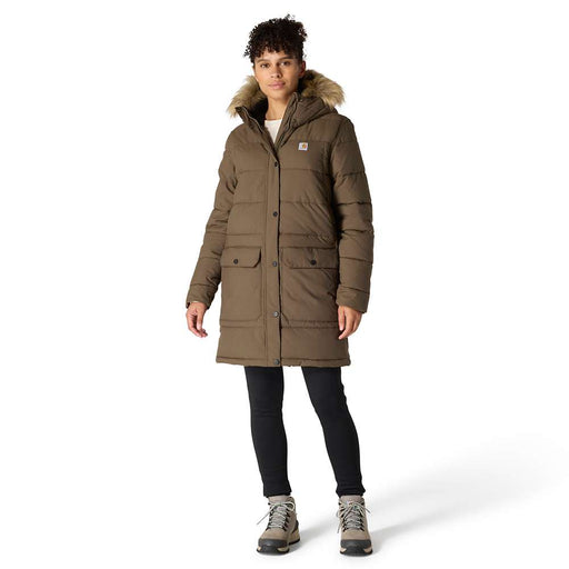 Woman with curly dark hair and light brown skin wearing a brown parka with faux fur trimmed hood, dark skinny jeans, and taupe winter boots. The parka hits a few inches above her knees, she is listed as 5 feet 8 inches tall.