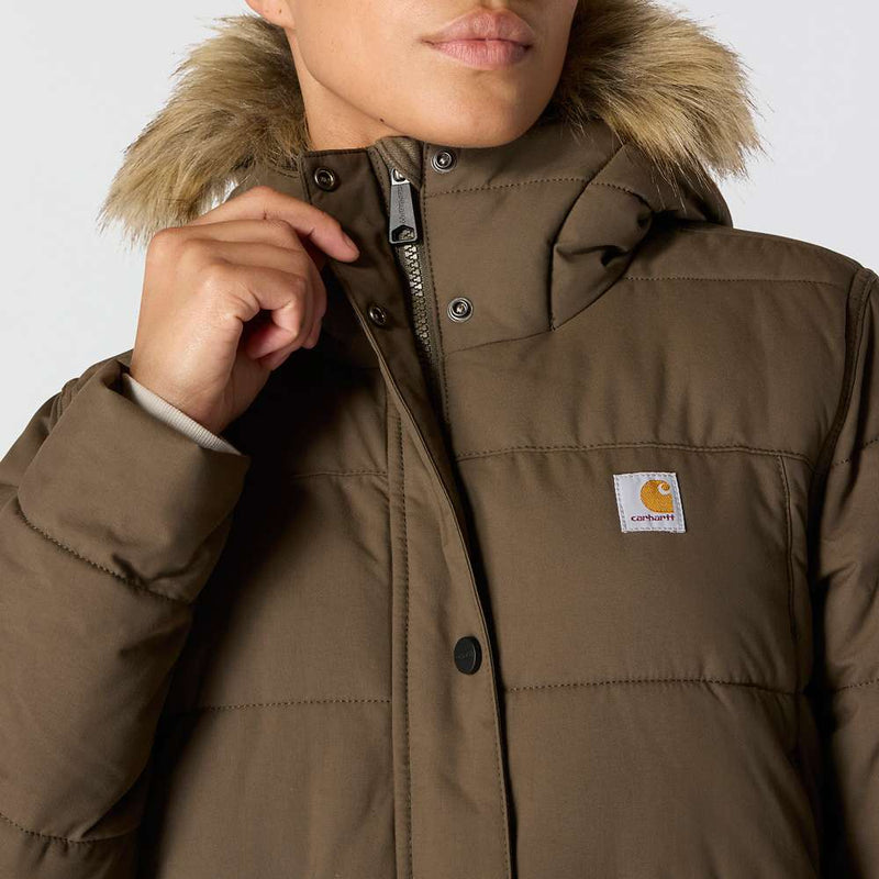 Close up of a woman wearing a tarmac brown colored parka with a fur lined hood against a white background. She is unbuttoning the very top of the jacket to reveal that it also has a zipper underneath.