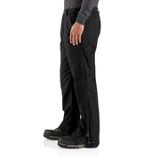 Side view of a man wearing loose fitting black work pants that open up on the side against a white background. 