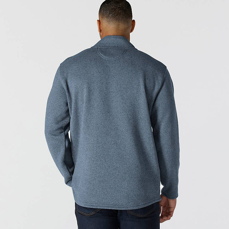 Zoomed out back-view of a man wearing a faded navy colored fleece jacket against a white background