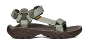 Side view of a dark brown sandal with green straps on a white background.