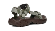 Side view of a dark brown sandal with green straps on a white background.