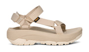 Side view of a beige platform sandal on a white background.