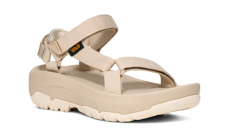 Side view of a beige platform sandal on a white background.