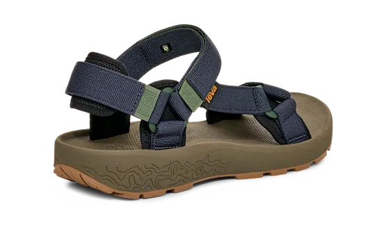 Side view of a ark green sandal with blue straps on a white background.