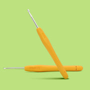 Yellow crochet hooks with silver ends on a green background
