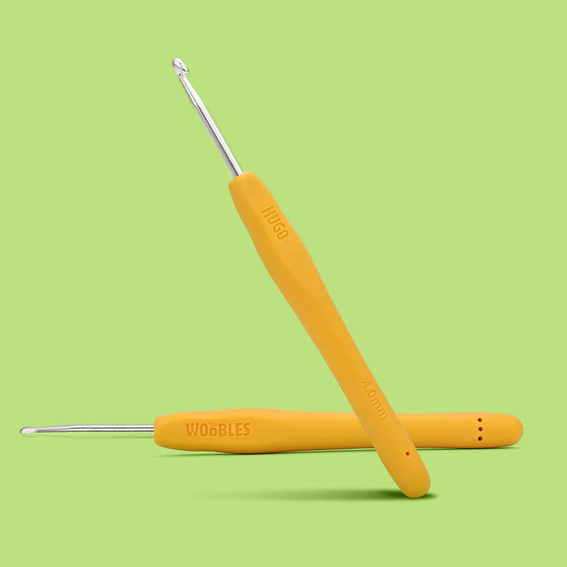 Yellow crochet hooks with silver ends on a green background