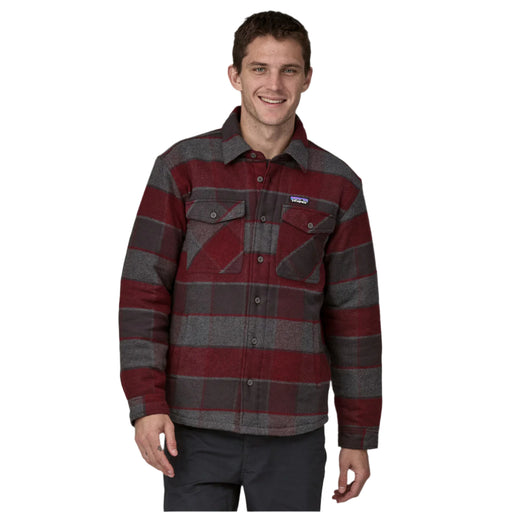 Man wearing a red and gray plaid shirt on a white background