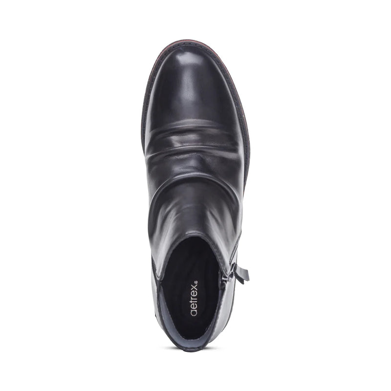 Black ankle boot with 'Aetrex' branding on a white background