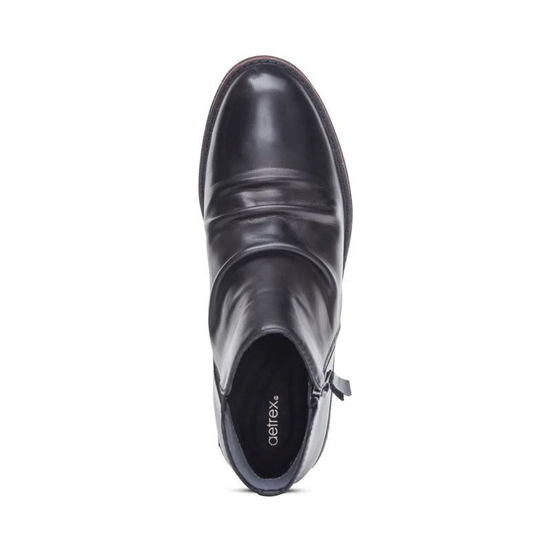 Black ankle boot with 'Aetrex' branding on a white background
