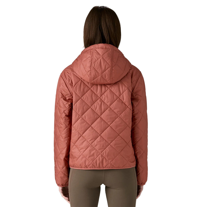 Person wearing a pink quilted jacket on a white background