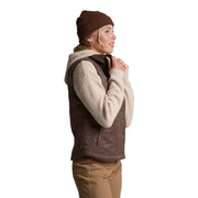 Person wearing a brown vest, beige sweater, and brown beanie on a white background