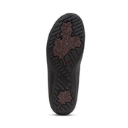 Bottom view of the tread of a shoe that features a dark purple colored leaf pattern on a black sole against a white background. 