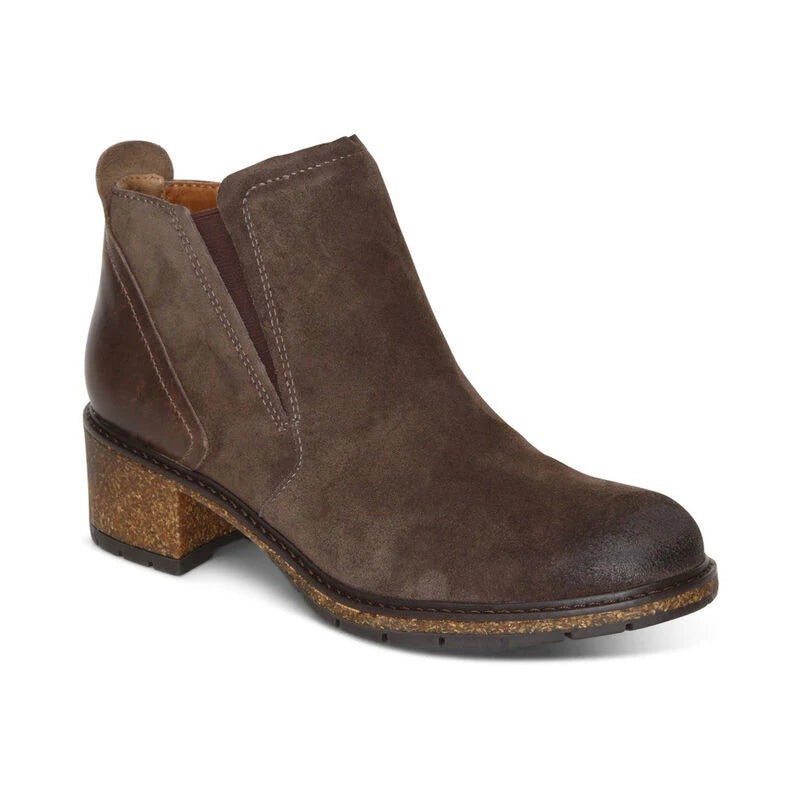 Side view of a dark brown ankle boot with a heel on the back of it against a white background. 