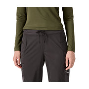 A model wearing dark gray outdoor cargo pants with a drawstring waist and an olive green long-sleeve top, shown from the chest down on a white background.