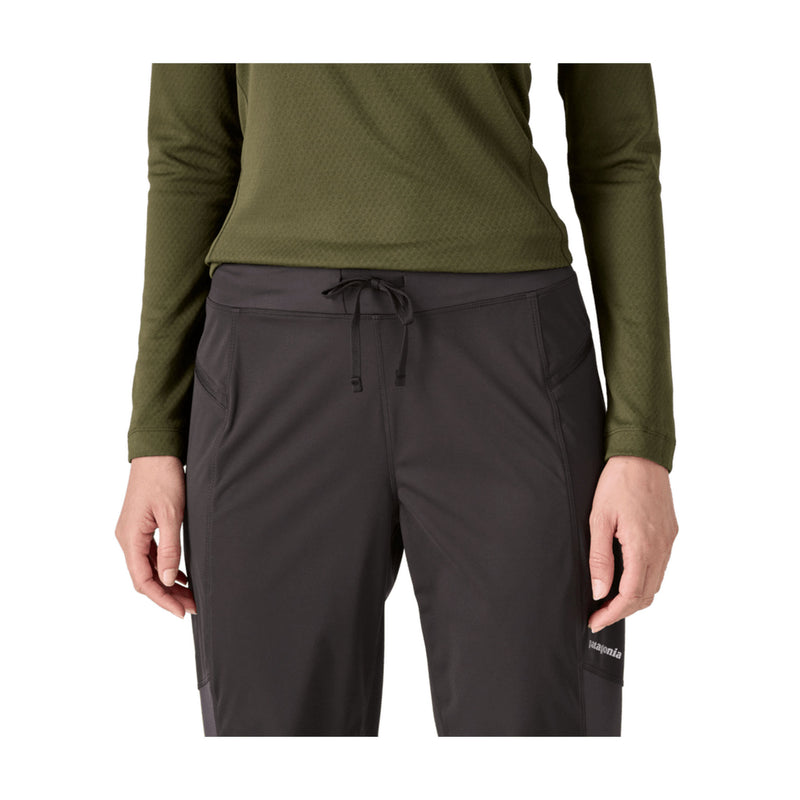 A model wearing dark gray outdoor cargo pants with a drawstring waist and an olive green long-sleeve top, shown from the chest down on a white background.