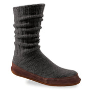 A black slipper sock with a purple bottom on a white background