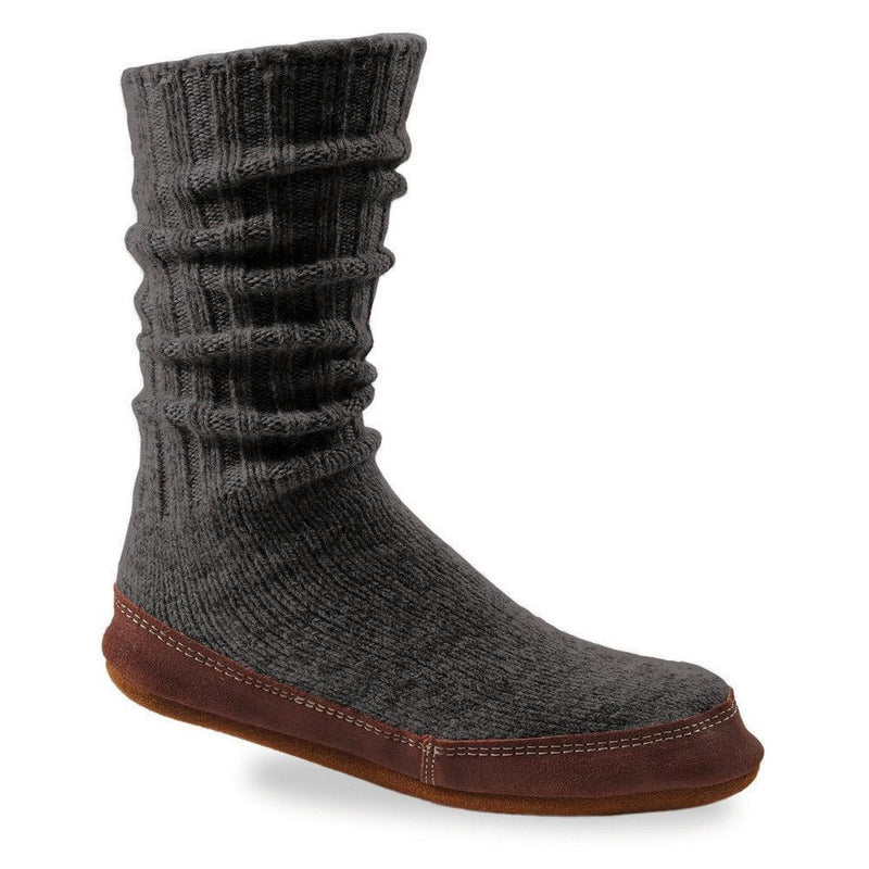 A black slipper sock with a purple bottom on a white background