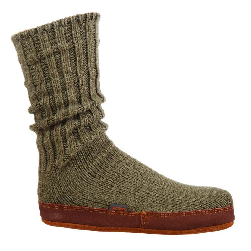 A green slipper sock with a brown bottom on a white background