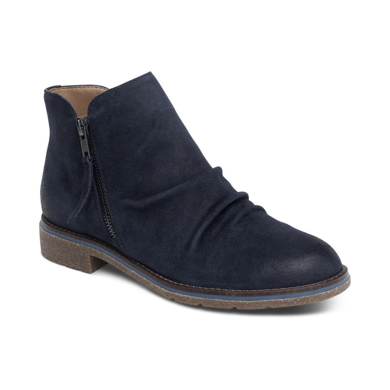Side view of a blue colored ankle boot against a white background. 