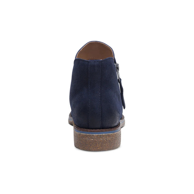 Back view of a blue colored ankle boot against a white background. 