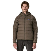 Man wearing a brown puffer jacket with a visible brand logo on a white background