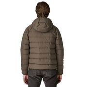 Person wearing a brown puffer jacket on a white background
