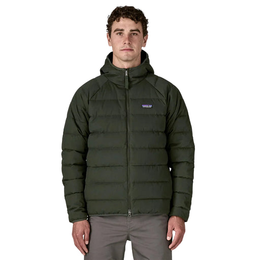 Man wearing a green puffer jacket with a brand logo on a white background