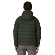 Person wearing a green puffer jacket on a white background