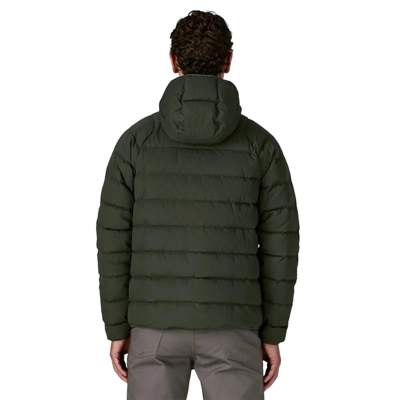 Person wearing a green puffer jacket on a white background