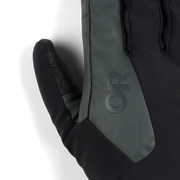 Close up of the thumb of a black and gray work glove featuring an Outdoor Research logo against a white background. 