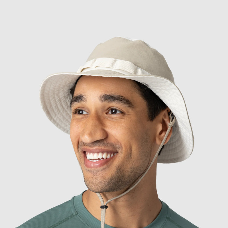 Man wearing a beige bucket hat with a white background