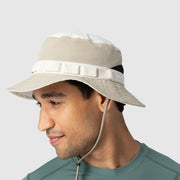 Man wearing a beige bucket hat with a white band on a light gray background