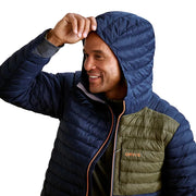 Man wearing a blue and green puffer jacket with 'Orvis' branding.