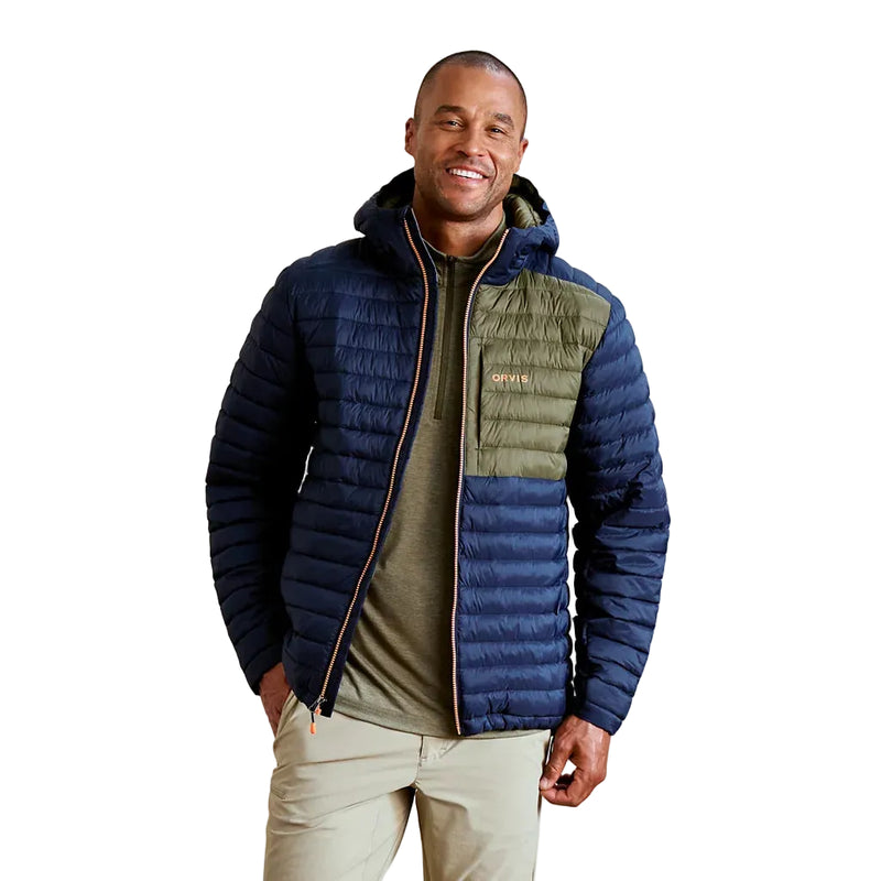 Man wearing a blue and green puffer jacket on a plain background