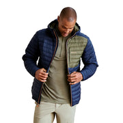 Man wearing a blue and green puffer jacket against a plain background