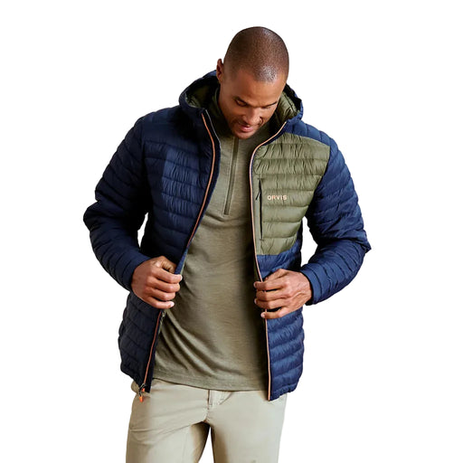 Man wearing a blue and green puffer jacket against a plain background