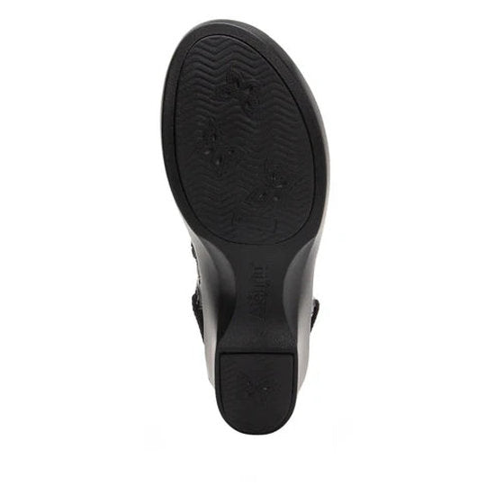 Bottom view of the black tread of a boot against a white background.