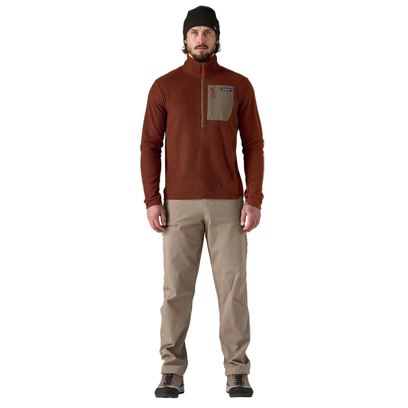 Man wearing a brown long-sleeve shirt and beige pants on a white background