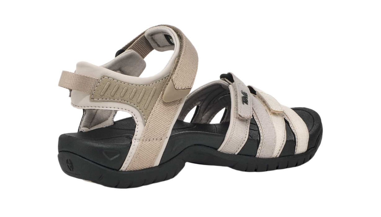 Rear view of beige and black sandals on a white background