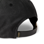 Close up back view of a black baseball cap featuring a Filson logo against a white background. 