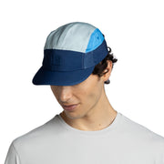 Person wearing a blue and gray cap on a white background